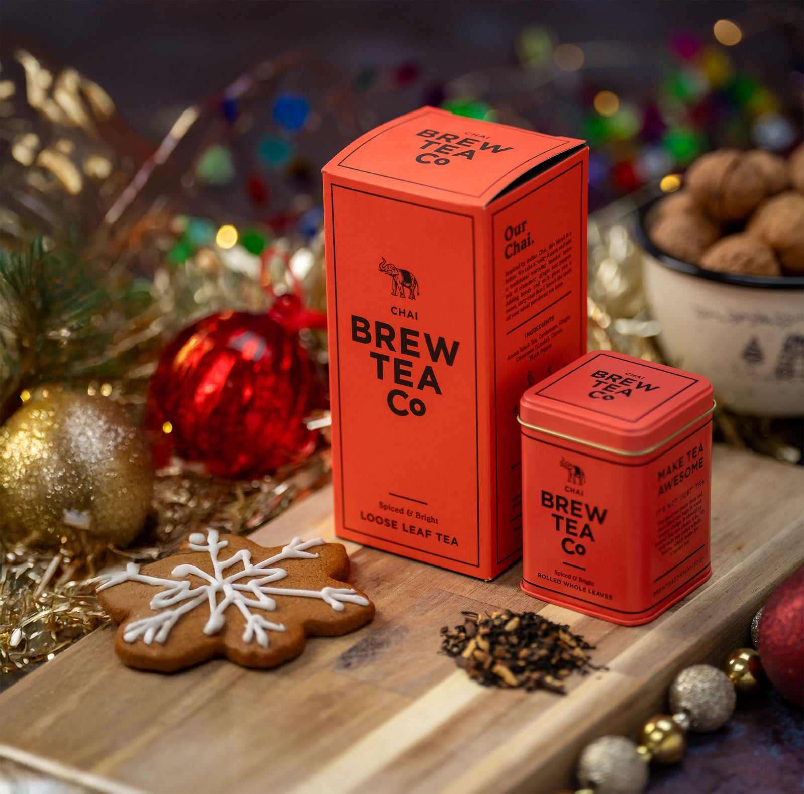 Red 'Brew Tea Co.' tea packaging with festive decorations on a wooden surface.